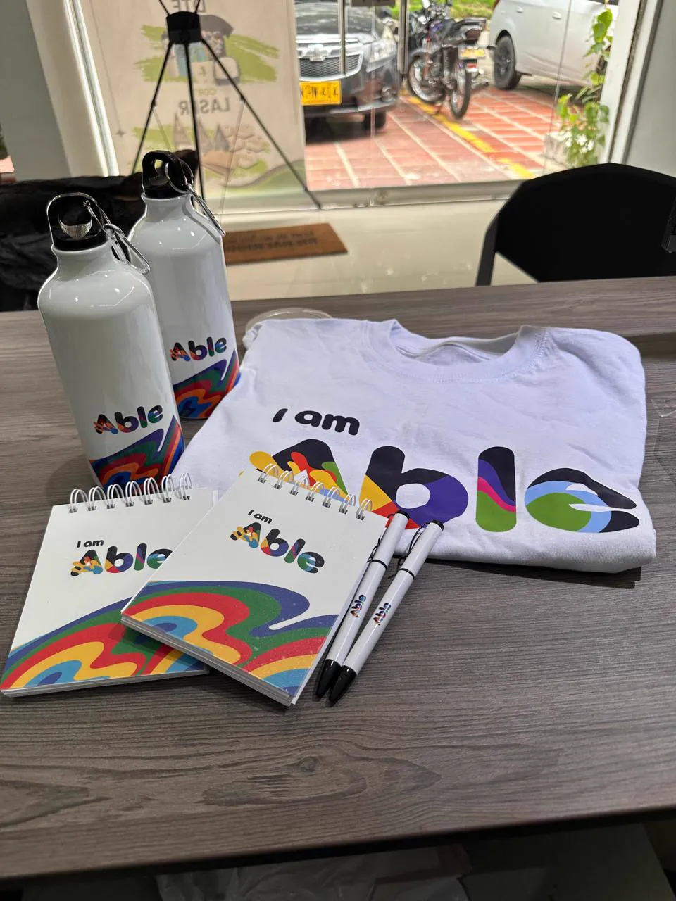 Merchandising I am Able: camiseta, termos, libretas y bolígrafos